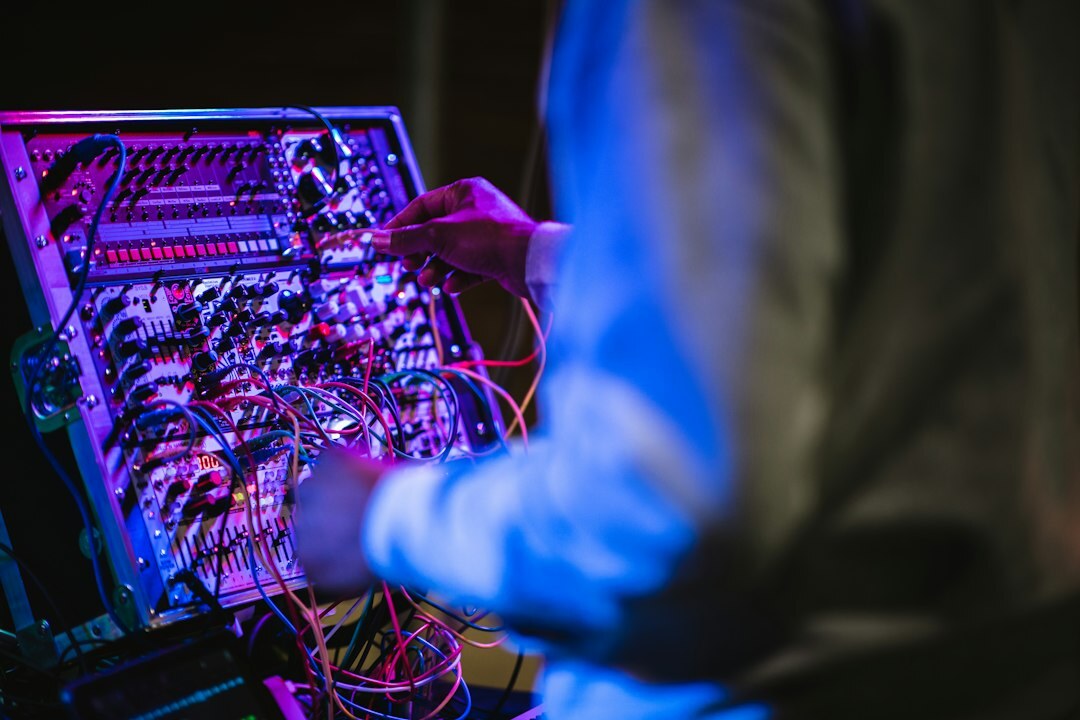 Sound engineer adjusting an audio mixing console with waveform displays
