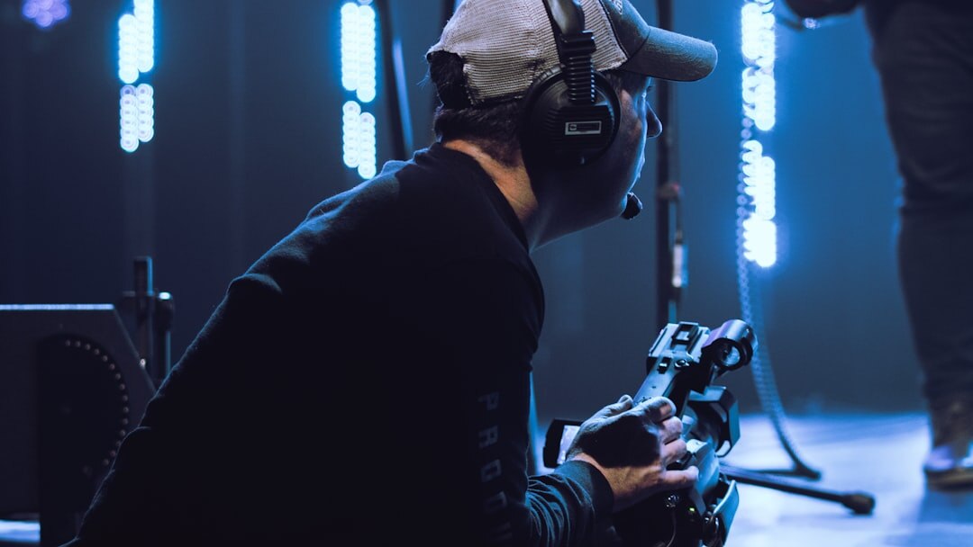British camera operator adjusting a broadcast camera on a studio floor